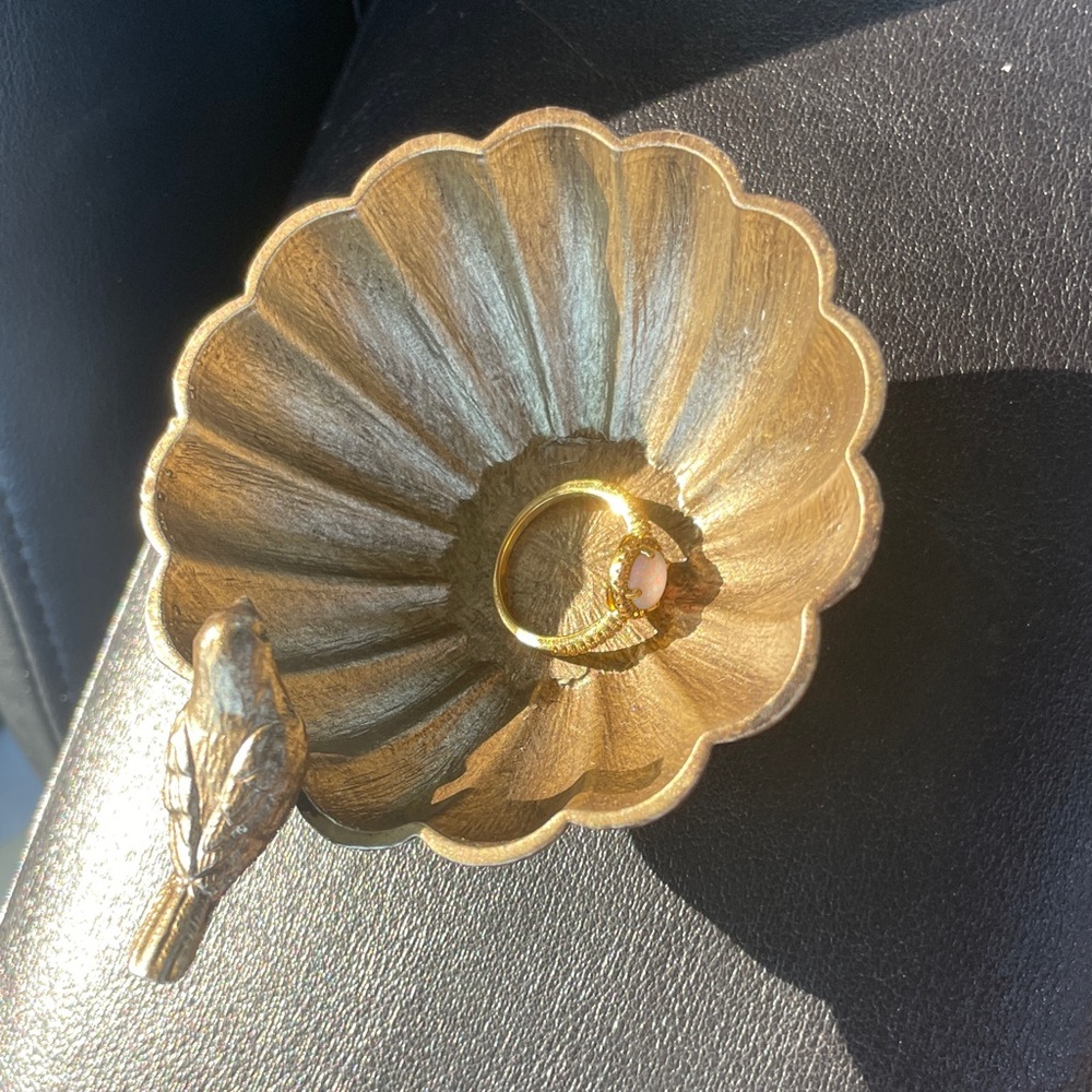 Gold Tone Ring with white stone and shades of pink in sunlight